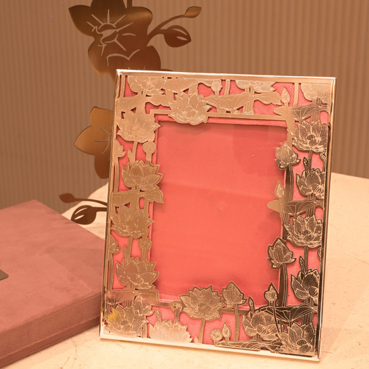 Decorative metal frame with floral patterns on a pink background