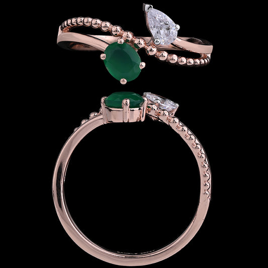 This is a stunning rose gold ring by jnjbymadhuri, featuring a captivating design with a central green gemstone complemented by a sparkling pear-shaped diamond and a delicate band with diamond accents. The combination of textures and gemstone cuts creates a modern yet timeless piece.