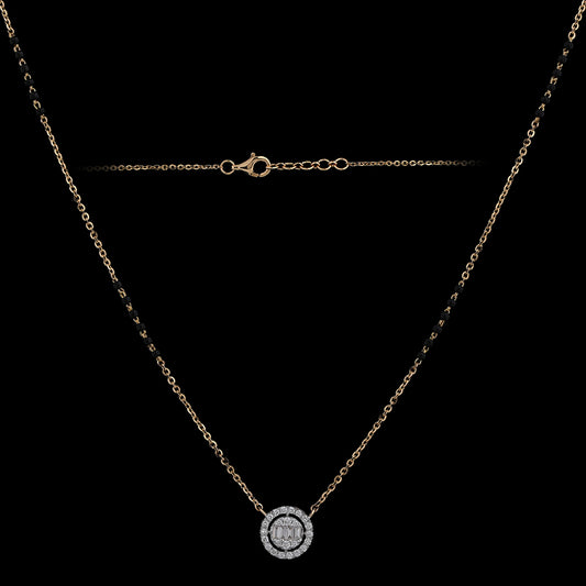 Elegant gold chain necklace with a round diamond pendant encased in a halo setting, exuding timeless charm. A delicate signature piece from jnjbymadhuri.
