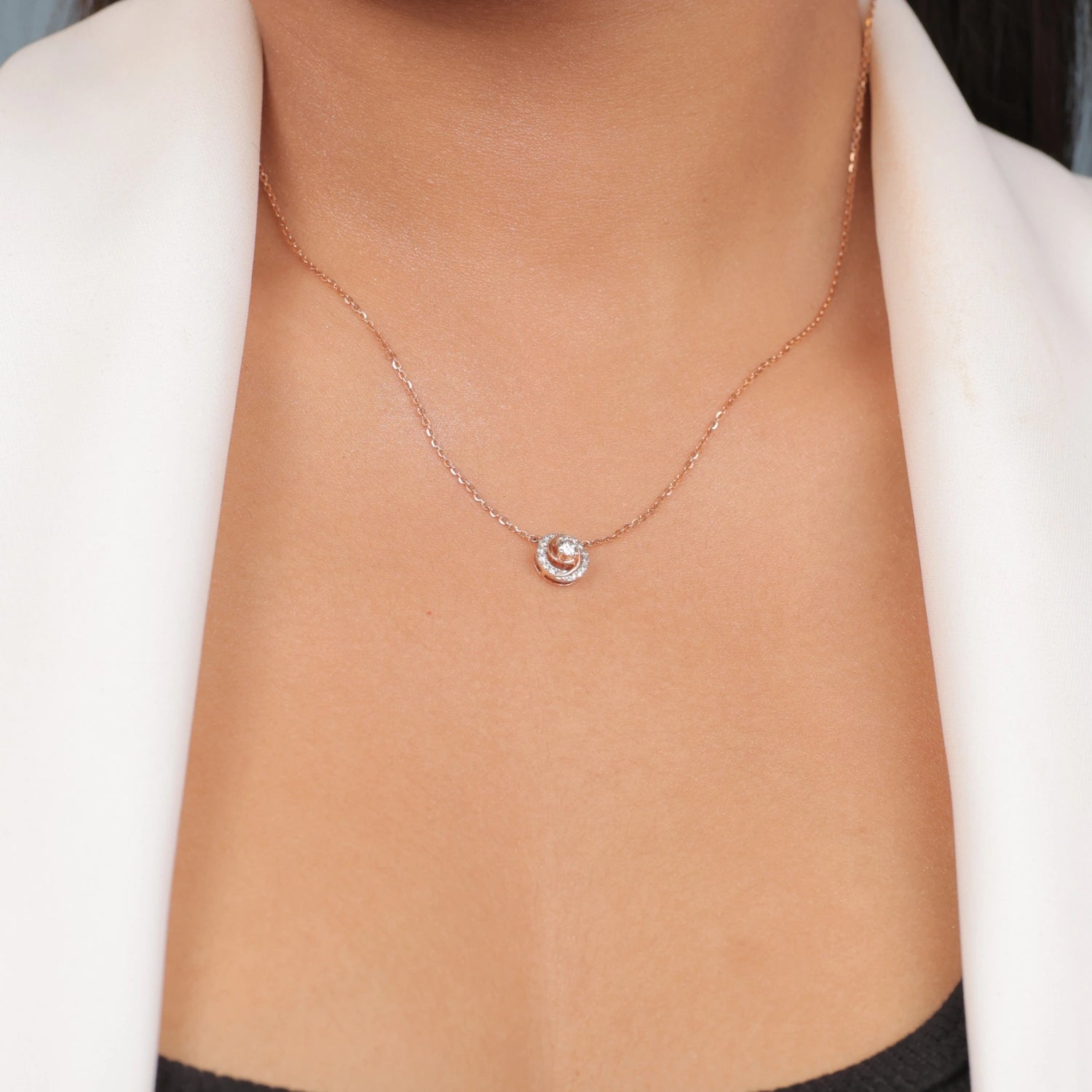 Elegant model wearing a minimalist diamond necklace by jnjbymadhuri, styled with a white blazer and black top for a modern, sophisticated look.
