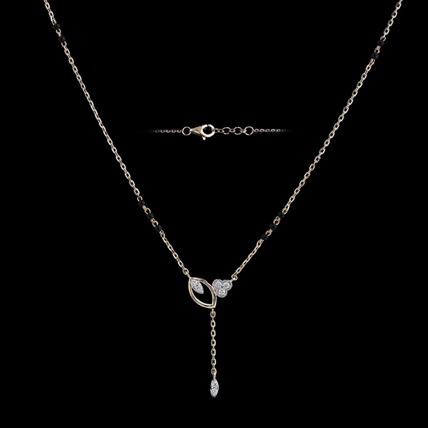 A beautifully crafted mangalsutra-style necklace with a sleek chain, black bead accents, and a modern circular pendant featuring a drop design is showcased against a black background. This elegant piece from jnjbymadhuri blends timeless charm with contemporary flair.