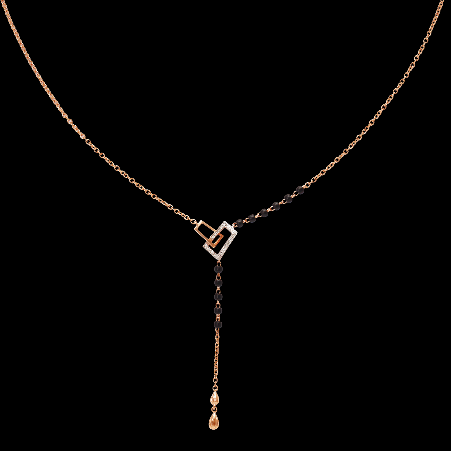 Elegant mangalsutra featuring a heart-shaped pendant with black beads delicately aligned along one side of the chain, complemented by a sleek gold drop, all set against a black background – jnjbymadhuri.