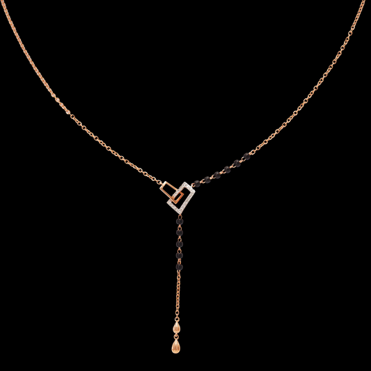 Elegant mangalsutra featuring a heart-shaped pendant with black beads delicately aligned along one side of the chain, complemented by a sleek gold drop, all set against a black background ā jnjbymadhuri.