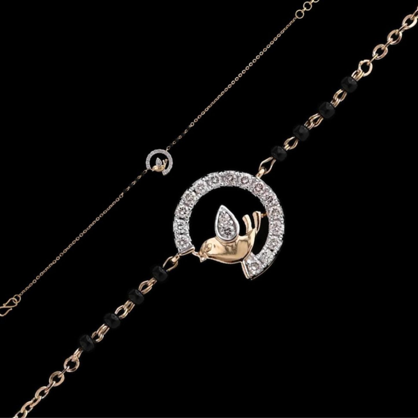 A stunning bracelet by jnjbymadhuri, featuring a rose gold bird perched within a sparkling diamond-studded semicircle. The elegant chain is adorned with black beads, creating a refined fusion of tradition and modern charm.