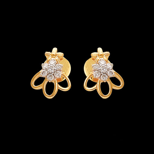 a pair of gold floral earrings with diamond centers and open petal-like loops, set against a black background — jewelry by jnjbymadhuri.