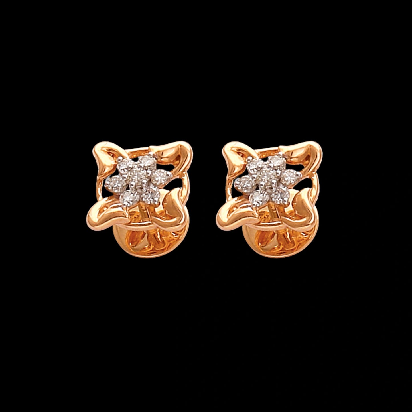 Stunning floral-inspired gold stud earrings designed by jnjbymadhuri, featuring a delicate four-petal motif with sparkling diamond accents, perfect for adding an elegant touch to both everyday and festive looks.