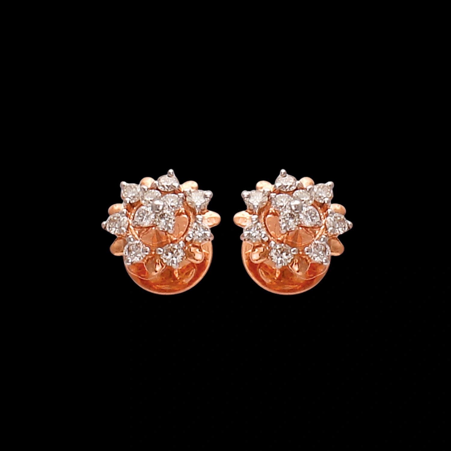 a pair of rose gold floral stud earrings with sparkling clustered diamonds on a black background — jewelry by jnjbymadhuri.