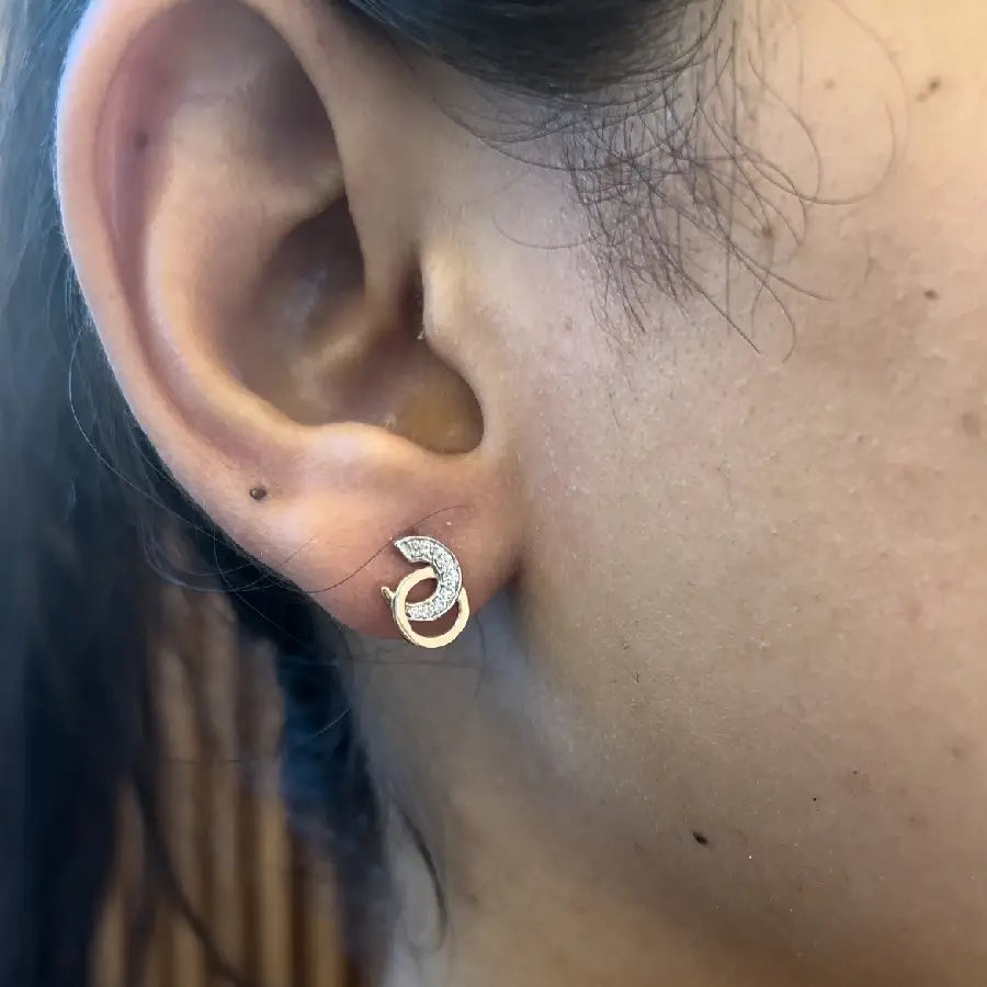 Elegant crescent-and-loop earrings worn snugly on the ear, showcasing a refined sparkle and modern charm. A versatile everyday accessory handcrafted by jnjbymadhuri.