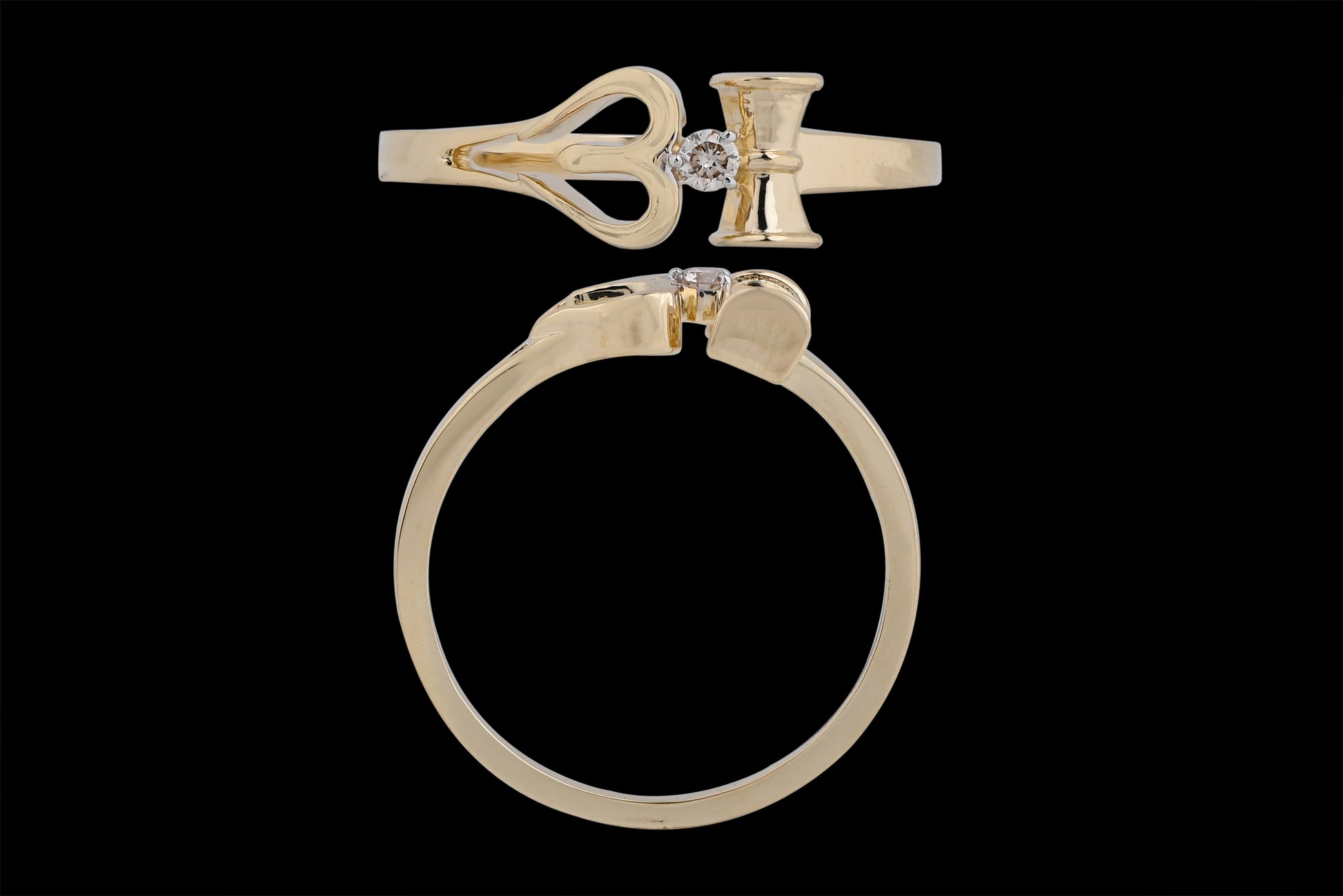 This is another view of the same distinctive gold ring, reinforcing its key design elements: the heart-shaped motif, vertical bar, and central diamond. The top-down and side angles clearly showcase the precision of the cut and symmetry, underlining its elegant yet symbolic appeal—an excellent representation of jnjbymadhuri's craftsmanship.