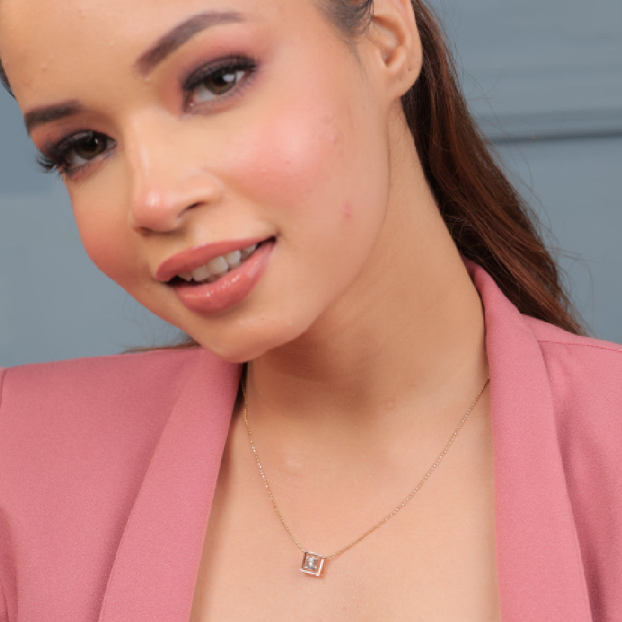 Model wearing a delicate rose gold diamond pendant necklace by jnjbymadhuri, paired with a pink blazer and natural makeup look, showcasing the elegant design of the jewelry.