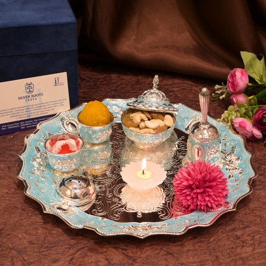 Decorative tray with candles, flowers, and small containers on a wooden surface.