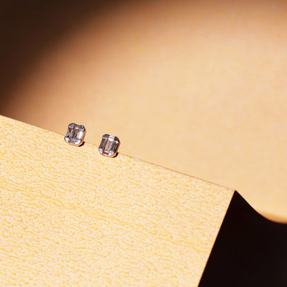 This photo showcases the same jnjbymaduri geometric rectangular stud earrings in a lifestyle setting. The minimal, reflective surface of the design pairs elegantly with the warm backdrop, highlighting their understated luxury—perfect for both daily wear and formal settings.
