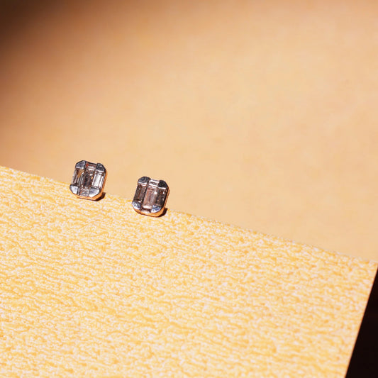 This photo showcases the same jnjbymaduri geometric rectangular stud earrings in a lifestyle setting. The minimal, reflective surface of the design pairs elegantly with the warm backdrop, highlighting their understated luxury—perfect for both daily wear and formal settings.
