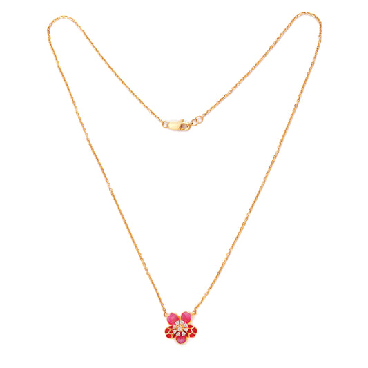 Delicate gold necklace by jnjbymadhuri featuring a floral pendant adorned with red and pink stones, displayed on a white background.
