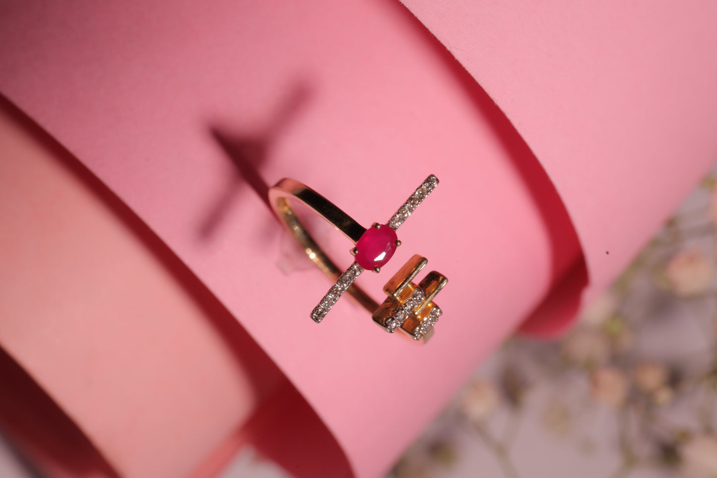 A stylish red gemstone ring with diamond accents, elegantly worn and showcased by a model. A signature statement piece from jnjbymadhuri, blending sophistication with modern charm.
