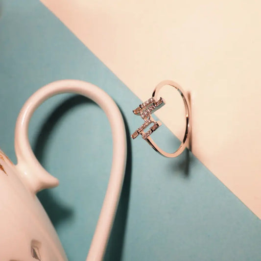 Minimalist rose gold ring featuring a zigzag design adorned with diamonds, photographed with soft pastel aesthetics. A contemporary charm from jnjbymadhuri.