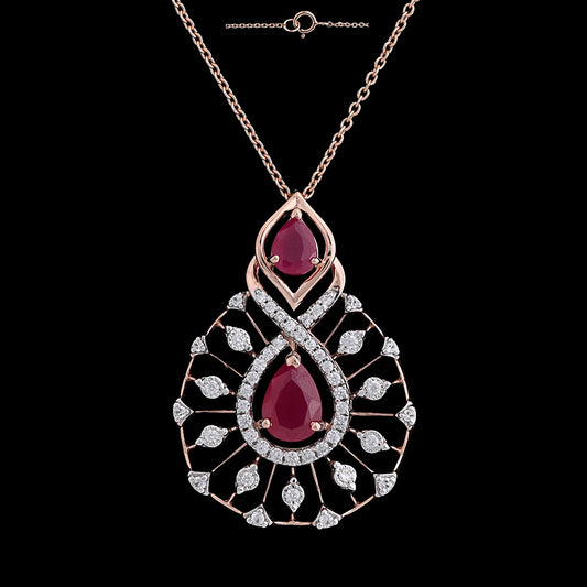 Elegant rose gold necklace with a dual ruby teardrop pendant and diamond detailing by jnjbymadhuri, displayed against a black background.
