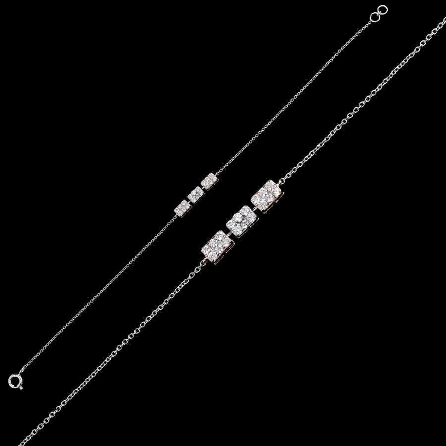 Sleek silver bracelet from jnjbymadhuri featuring three geometric diamond-studded cube charms on a fine chain, displayed on a black background for a modern, elegant look.

