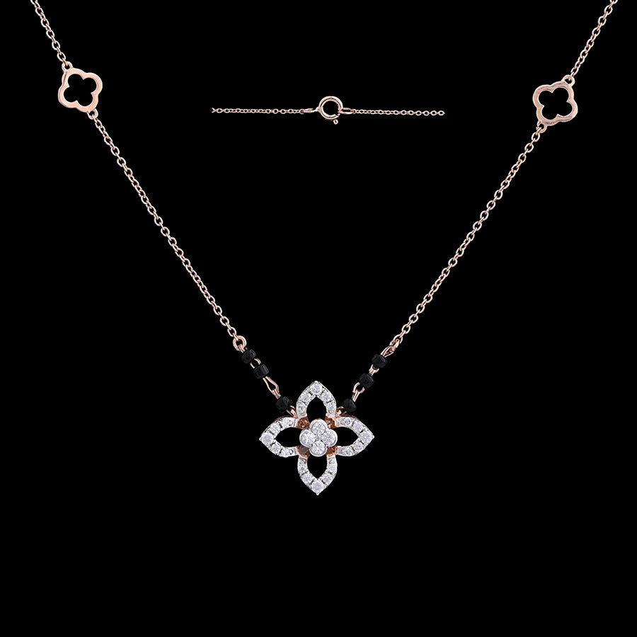 "Stylish rose gold mangalsutra necklace with a diamond-studded floral pendant and black beads, shown against a black background with matching floral motifs on the chain by jnjbymadhuri."
