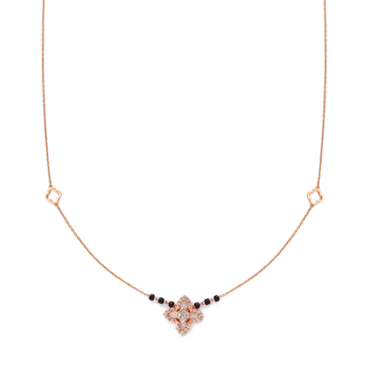 "Elegant rose gold mangalsutra necklace by jnjbymadhuri, featuring a floral pendant design with black beads on a delicate chain, displayed on a white background."
