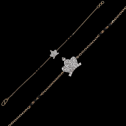 Elegant crown-themed bracelet from jnjbymadhuri adorned with shimmering diamonds and traditional black beads, displayed on a black background for a luxurious look.
