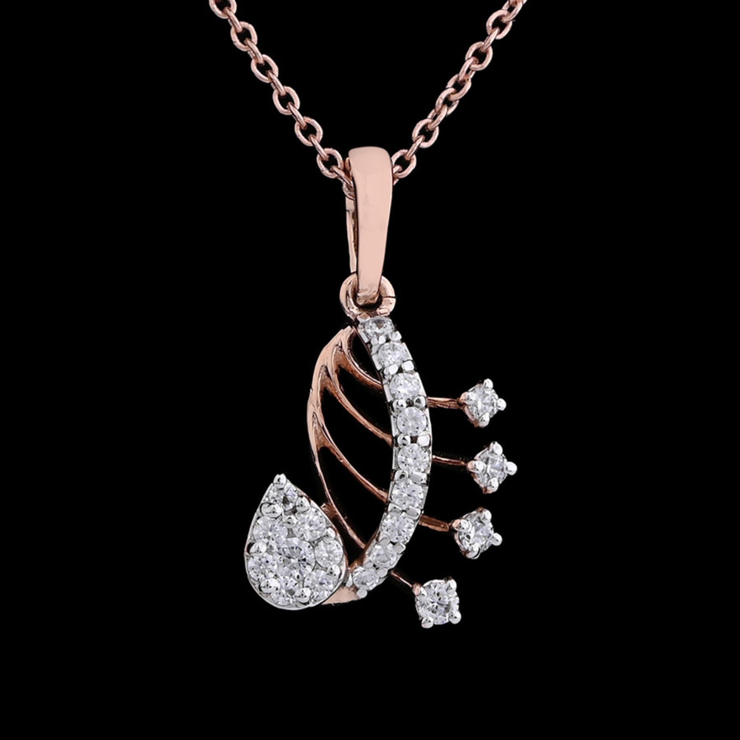 Close-up of a rose gold paisley-shaped pendant necklace by jnjbymadhuri, featuring intricate design with white stones and hanging diamond-like elements, set against a black background.

