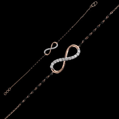 Graceful bracelet showcasing an infinity symbol encrusted with shimmering stones on a sleek black and gold chain. A timeless charm crafted by jnjbymadhuri.
