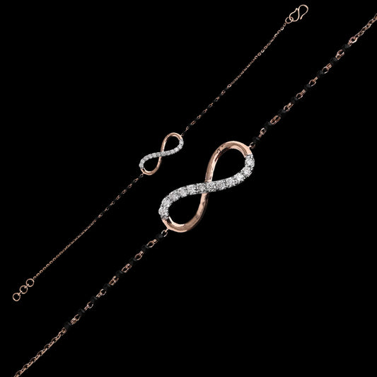 Graceful bracelet showcasing an infinity symbol encrusted with shimmering stones on a sleek black and gold chain. A timeless charm crafted by jnjbymadhuri.
