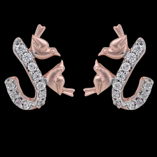 Close-up image of exquisite rose gold earrings by jnjbymadhuri, featuring a graceful design of two perched birds on a diamond-studded, curved vine motif, blending whimsical elegance with fine craftsmanship.
