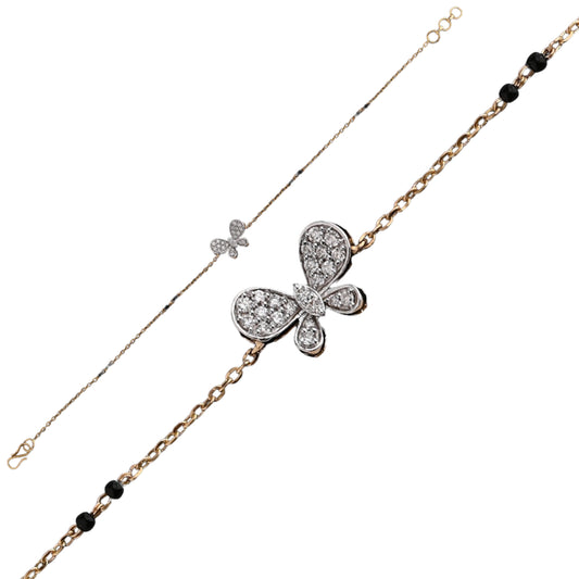 A delicate and elegant bracelet by jnjbymadhuri, featuring a charming butterfly centerpiece encrusted with sparkling diamonds. The bracelet combines a fine dual-tone chain—one side in sleek white metal and the other in warm yellow gold—accented with small black beads for a graceful contrast. This refined piece showcases intricate craftsmanship and a whimsical yet sophisticated design.

