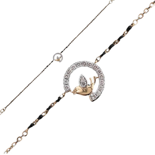 A charming bracelet by jnjbymadhuri, featuring a diamond-studded bird perched inside a sparkling semicircle on a two-tone chain. The design blends elegance and playfulness, accented with black beads for a unique, graceful touch.
