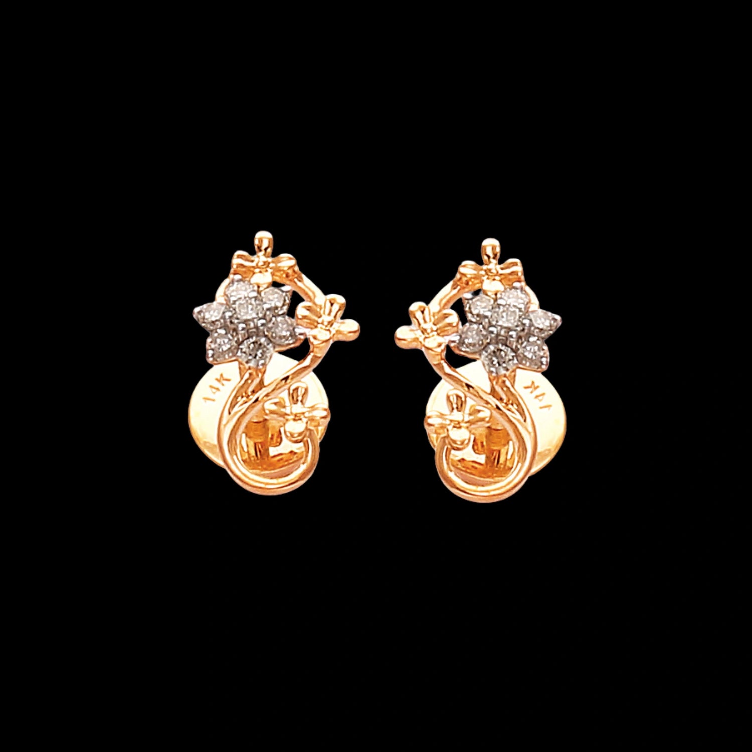 Elegant floral stud earrings by jnjbymaduri, crafted in gold and adorned with radiant diamond clusters, offering a timeless design for graceful sophistication.
