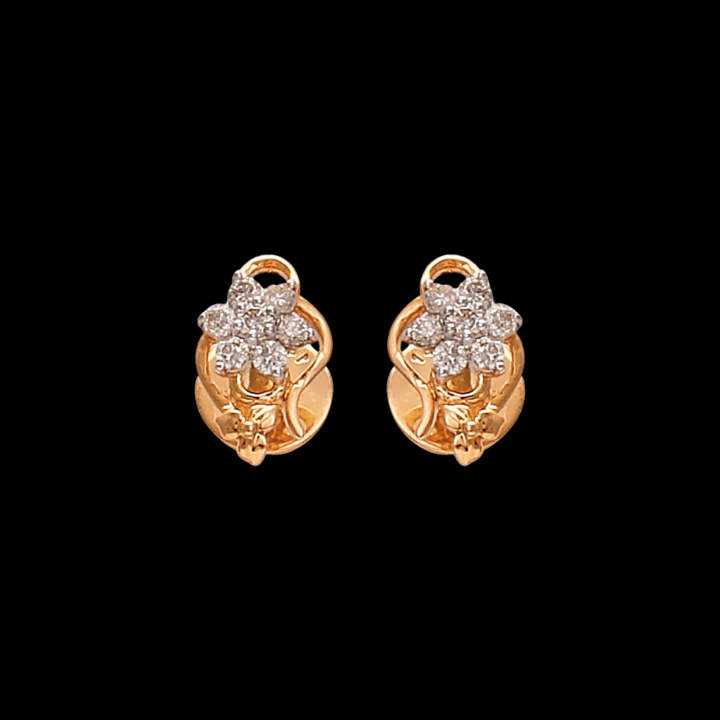 Gold floral stud earrings by jnjbymaduri, adorned with shimmering diamonds arranged in a flower motif, exuding timeless charm and sophistication suitable for both everyday wear and special occasions.
