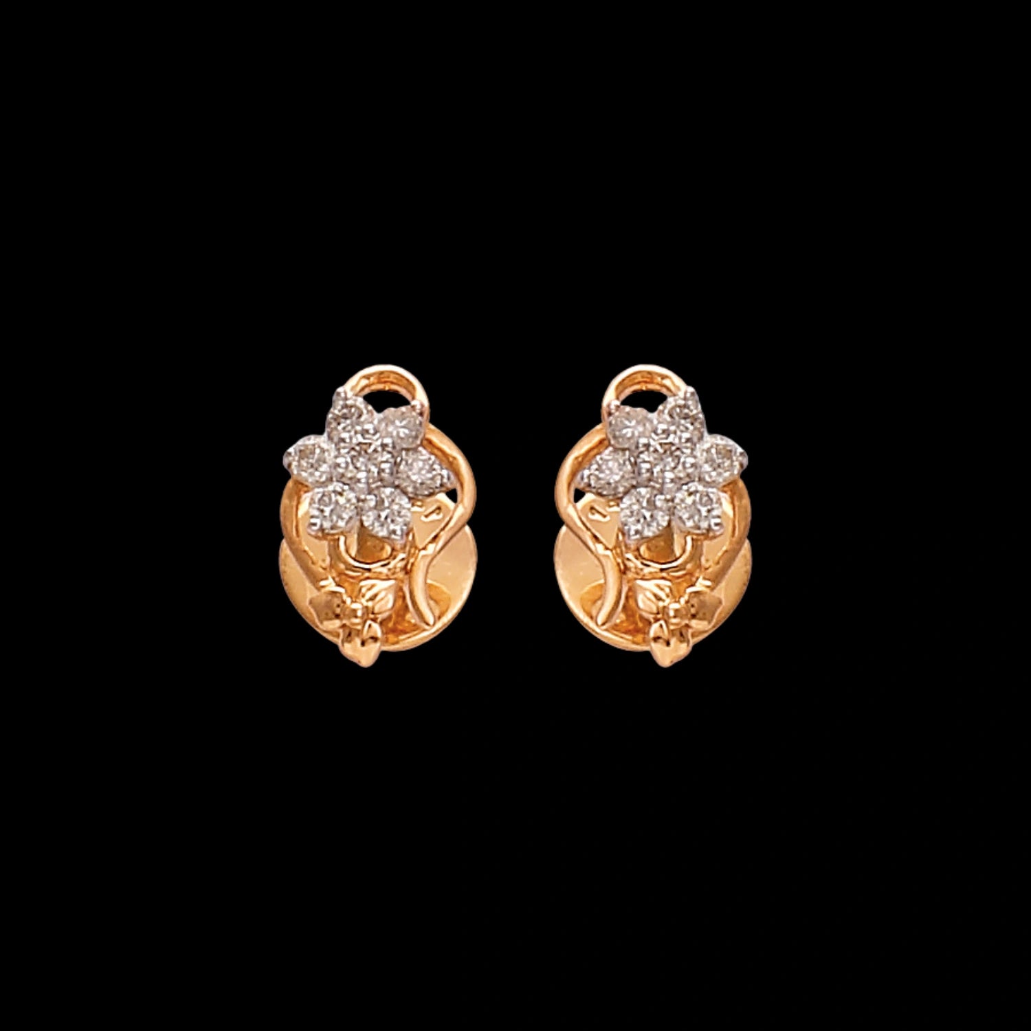 Gold floral stud earrings by jnjbymaduri, adorned with shimmering diamonds arranged in a flower motif, exuding timeless charm and sophistication suitable for both everyday wear and special occasions.
