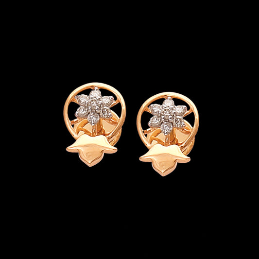 These exquisite gold stud earrings by jnjbymadhuri feature a radiant floral diamond centerpiece encased in a circular frame, accentuated with a unique petal-inspired base, creating a perfect balance of elegance and sophistication.