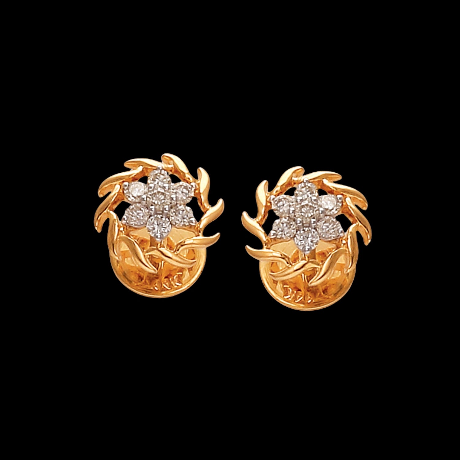 A pair of exquisite gold earrings by jnjbymadhuri, designed with intricate leaf motifs encircling a floral cluster of brilliant-cut diamonds. Set against a deep black background, the design exudes timeless elegance and showcases the brand’s craftsmanship in luxury fine jewelry.
