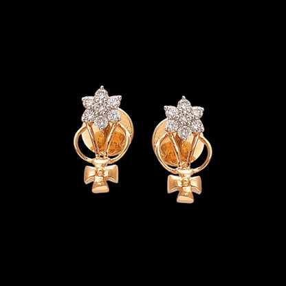 gold stud earrings featuring a floral diamond cluster at the top, with a gold ribbon-like design and bow-shaped detail at the bottom — displayed on a black background.
