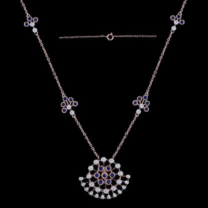Stunning rose gold necklace with a floral fan-shaped pendant, embellished with black and white stones, and matching motif accents along the chain. A refined and artistic design by jnjbymadhuri.
