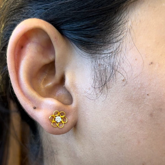 Delicate gold floral stud earring with a sparkling diamond center, adding a touch of elegance to everyday wear. Gracefully crafted by jnjbymadhuri.

