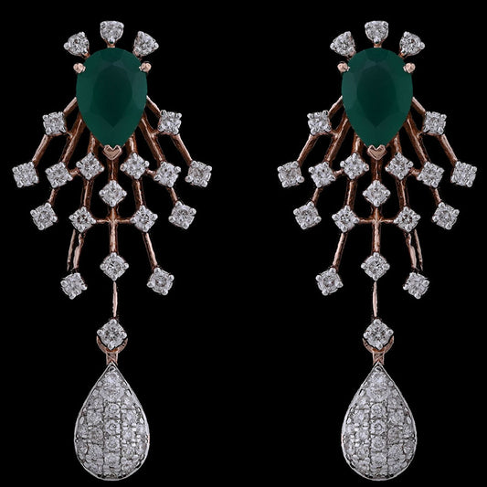 Exquisite earrings featuring emerald green stones, diamond-studded latticework, and teardrop danglers. A dazzling creation from jnjbymadhuri.
