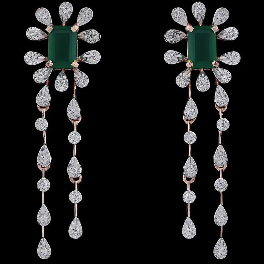 Elegant floral drop earrings featuring a central green gemstone surrounded by teardrop diamonds and twin cascading strands, set in rose gold. A luxurious statement piece by jnjbymadhuri.
