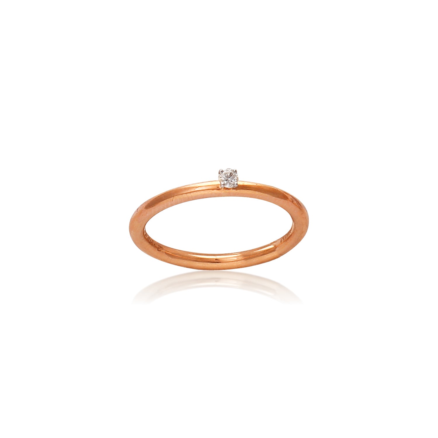 "Minimalist rose gold solitaire ring by jnjbymadhuri featuring a single round diamond on a white background."
