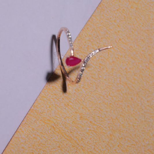 Delicate rose gold ring featuring a heart-shaped ruby centerpiece with a curved diamond-studded band. A graceful design by jnjbymadhuri.
