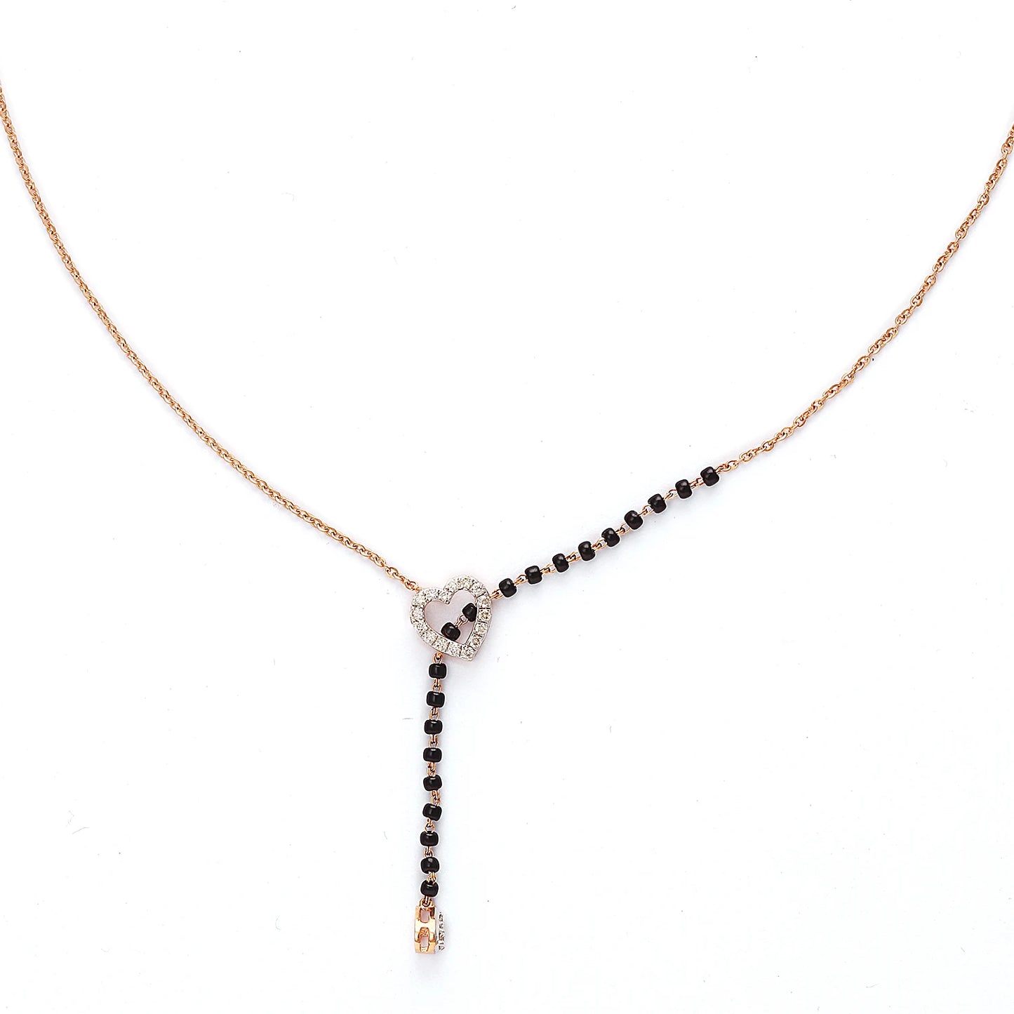 This image showcases a sleek heart-shaped mangalsutra design. It features a modern rose gold chain with a delicate black-beaded section flowing through a central, silver-tone heart charm. The heart is subtly adorned with sparkling stones, and a single drop at the end adds elegance. This piece blends contemporary aesthetics with traditional symbolism beautifully.
